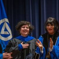 Provost Mili and President Mantella are all smiles with woman on stage